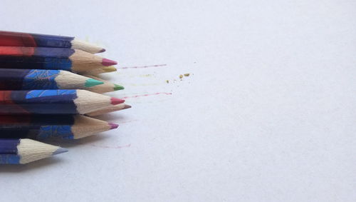 High angle view of multi colored pencils against white background