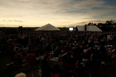 Crowd at market against sky during sunset