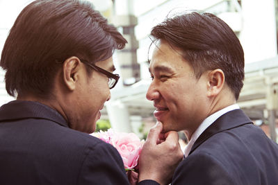 Close-up of gay couple smiling during wedding ceremony