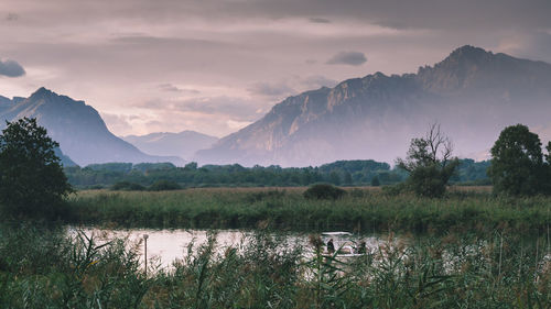 Scenic view of lake by mountains against sky