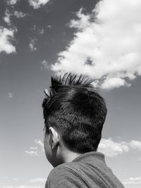 Close-up boy against sky in sunny day