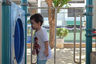 Boy standing by slide in playground
