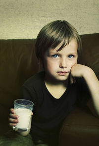 Close-up portrait of boy having milk at home
