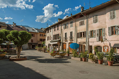 Square with stone building and shops in conflans, france.