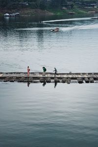 Man photographing woman while standing on pier