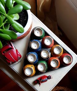 Close-up of multi colored candles and plant on table