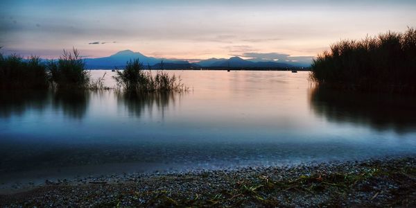 Scenic view of lake against sky at sunset