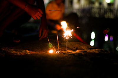 People with lit sparklers at night