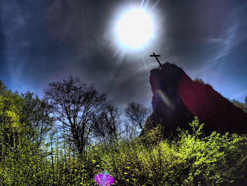 Low angle view of silhouette sculpture on land against sky