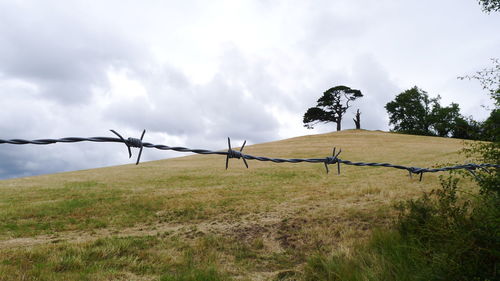 Fence on field against sky