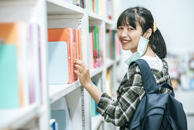 Portrait of a smiling young woman reading book