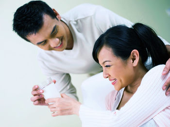 Man giving milk to pregnant wife at home