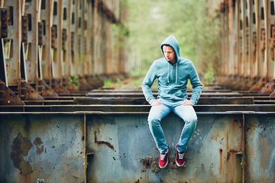 Full length of man sitting outdoors