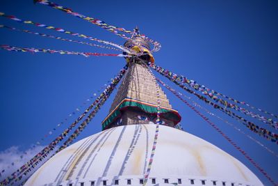 Low angle view of ferris wheel against blue sky