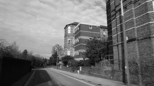 Road in city against cloudy sky