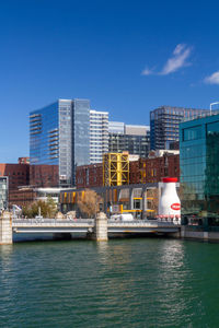 River by buildings against blue sky