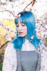 Young woman looking at camera while standing by plants