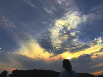 Silhouette of landscape against cloudy sky at sunset