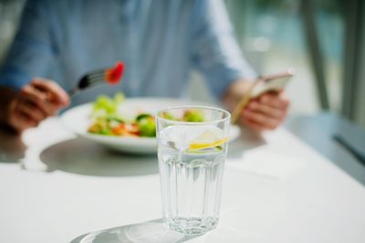 Midsection of woman holding drink on table