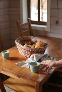 Cropped hand of person holding coffee cup on village breakfast in the morning