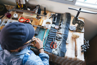 High angle view of tailor working on table at workshop