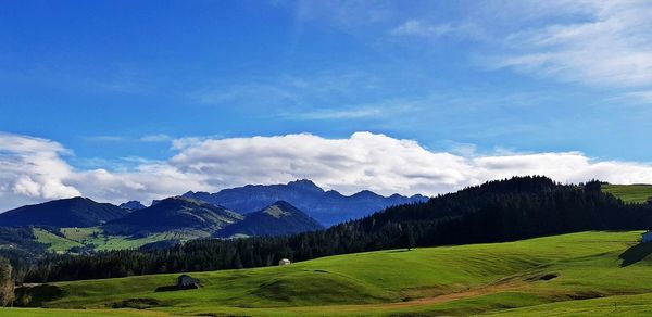 Scenic view of mountains against blue sky