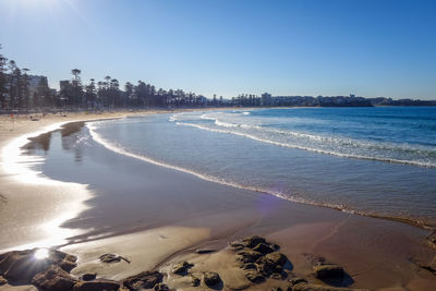 Scenic view of beach against clear blue sky