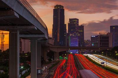 High angle view of light trails on city at sunset