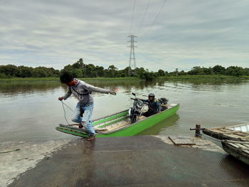 People on lake against sky