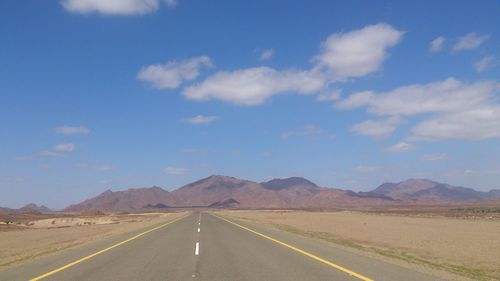 Empty road with mountains in background