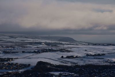 Scenic view over snow covered moorland with low cloud in winter