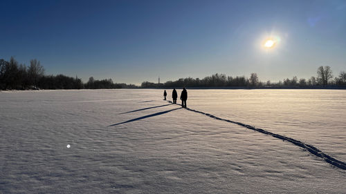 Rear view of woman walking on snow covered landscape