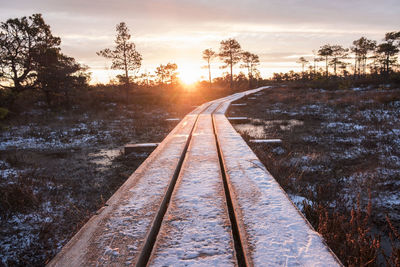 Railroad tracks against sky during sunset