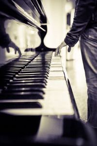 Low section of man playing piano