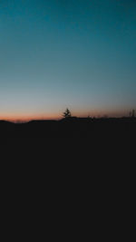 Silhouette landscape against clear sky during sunset