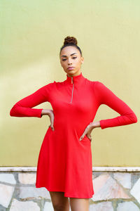 Portrait of young woman standing against wall