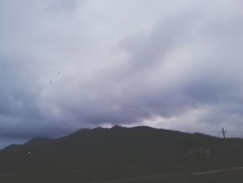 Scenic view of mountains against cloudy sky