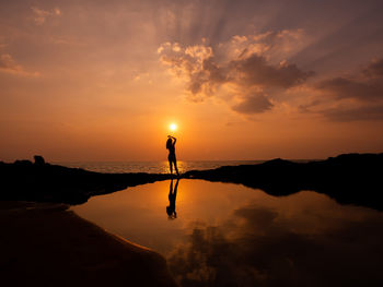 Beautiful silhouette woman at heavenly sunset at sea. sunlight sky at the sunset at the horizon