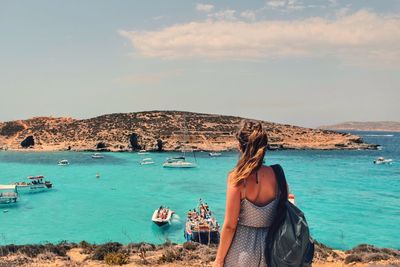 Rear view of woman looking at sea against sky