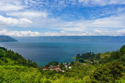 Scenic view of sea and mountains against sky