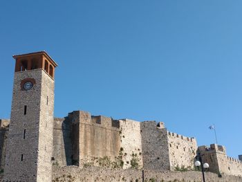 Low angle view of fort against clear blue sky