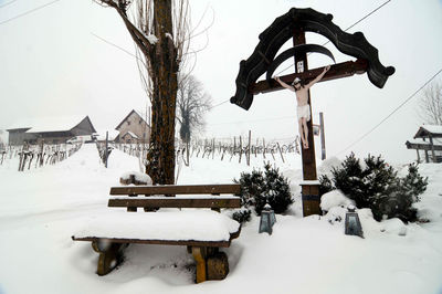 Gazebo on snow covered field against sky