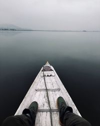 Low section of man sitting in rowboat in lake