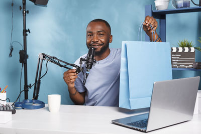 Man using laptop while sitting on table