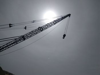 Low angle view of silhouette cranes against sky at dusk
