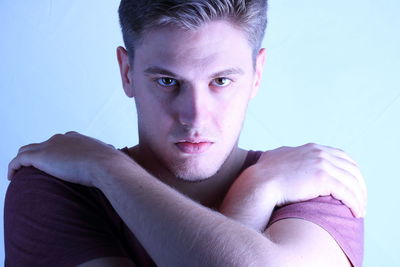 Close-up portrait of young man against gray background