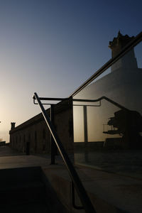 Low angle view of silhouette building against clear sky