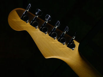 Close-up of guitar against black background