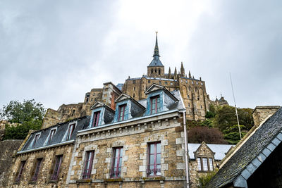 Low angle view of mont saint-michel against sky