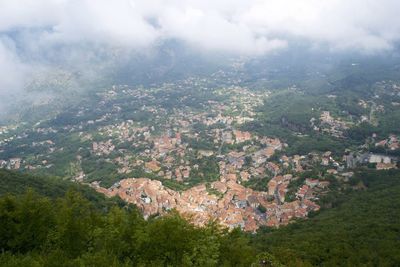 High angle view of town in valley against cloudy sky
